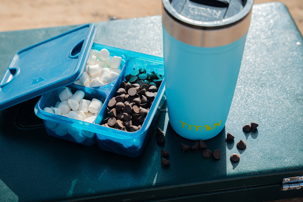 Homemade hot coco ingredients in an Arctic Zone food container next to a Titan 20 Oz Stainless Steel Tumbler